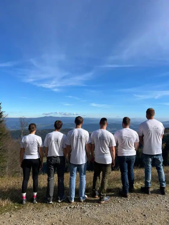 Team im IRS-Shirt beim Ausflug mit Blick über die Landschaft