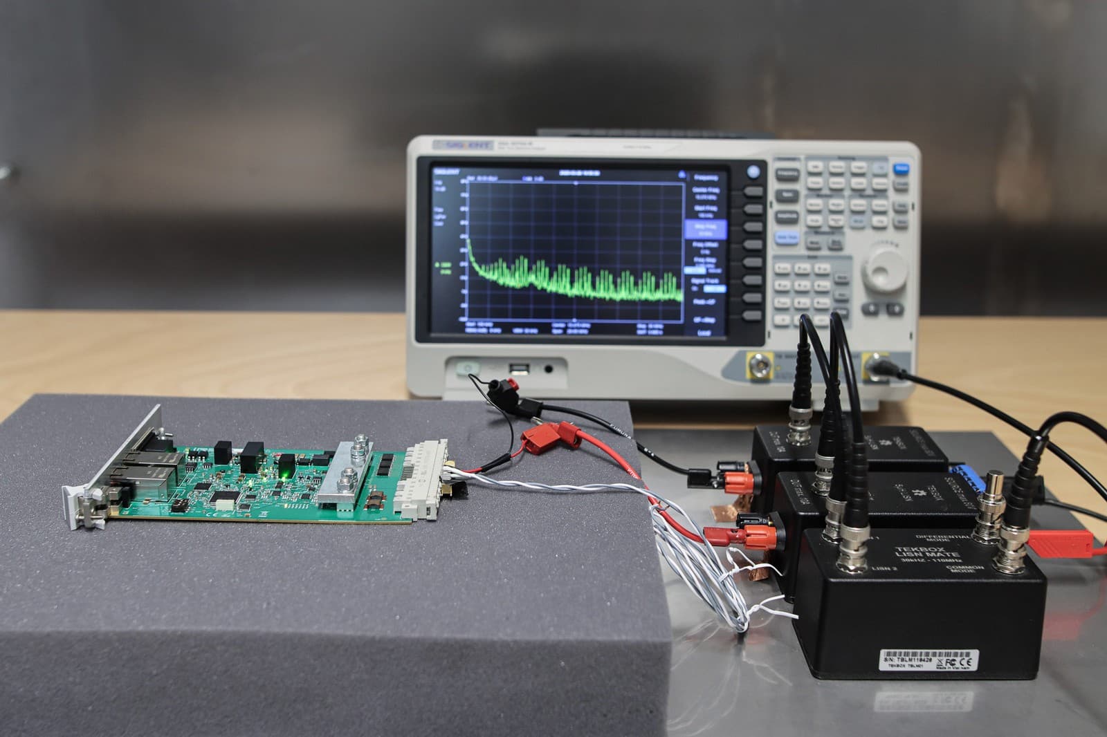Circuit board on conductive foam, connected to a spectrum analyzer and LISN